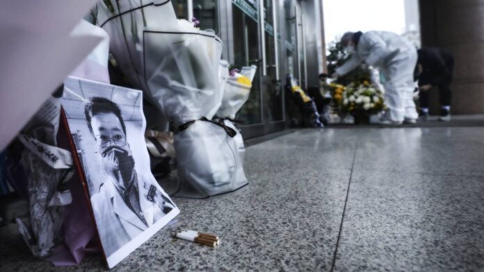 People Paying Condolence With Flowers In Front Of The Late Dr. Li Wenliang Photo.