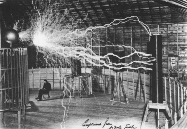 1899 में कोलोराडो स्प्रिंग्स एन में अपने ट्रांसमीटर के पास टेस्ला। तस्वीर में डिवाइस तारों के बिना बड़ी दूरी पर लाखों वोल्ट बिजली संचारित करने में सक्षम था।
