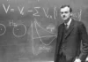 Paul Dirac standing in front of the blackboard