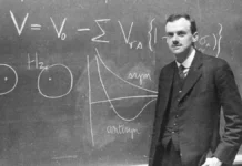 Paul Dirac standing in front of the blackboard