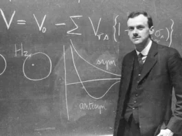 Paul Dirac standing in front of the blackboard