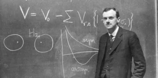 Paul Dirac standing in front of the blackboard